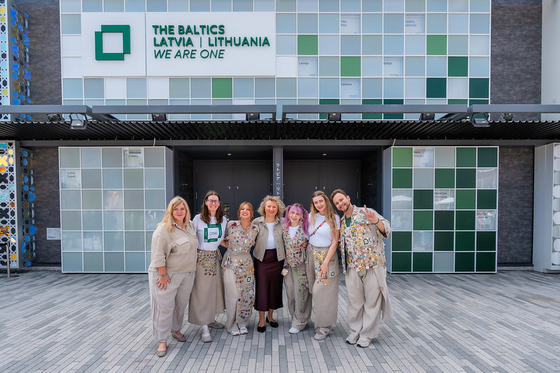 Команда сотрудников позирует у входа в павильон «The Baltics: Latvia | Lithuania — We Are One» на Expo 2025 в Осаке.